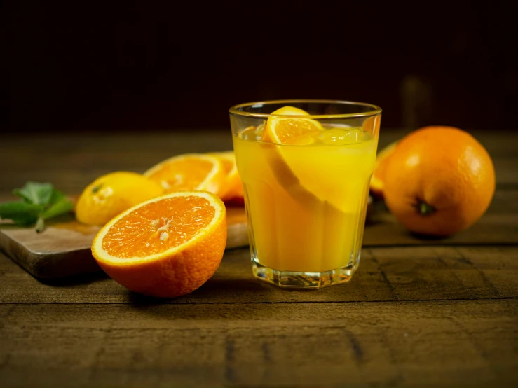 a glass of orange juice sitting on top of a wooden table, 🍸🍋, thumbnail, grey orange, citrinitas