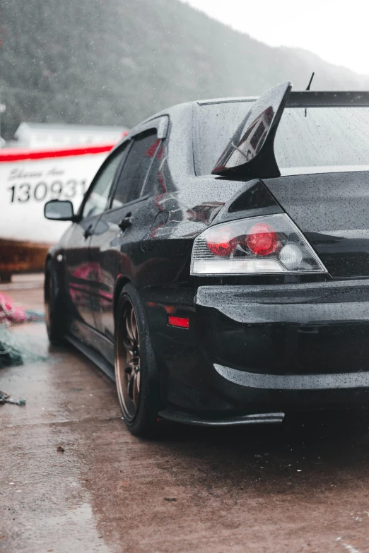 a black car on a rainy street parked