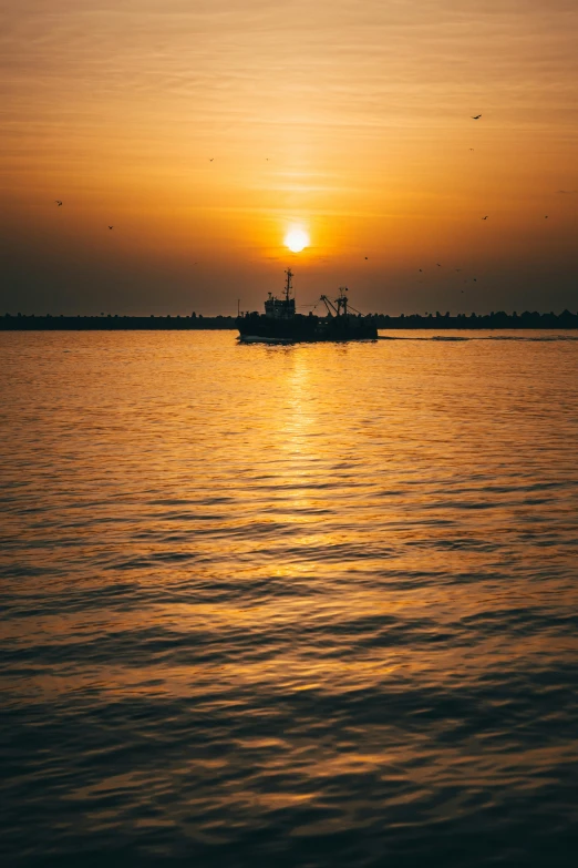 a boat floating on top of a large body of water, pexels contest winner, dappled golden sunset, fishing boat, gulf, dredged seabed