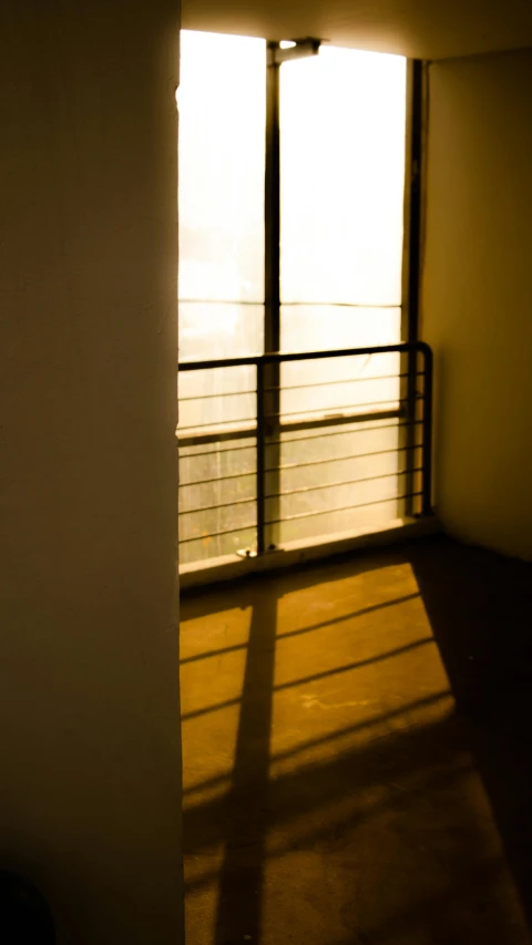 a room with a balcony and a view of the ocean, an album cover, inspired by Elsa Bleda, light and space, (golden hour), shadow cast of dark corridor, taken in the late 2010s, isolate translucent