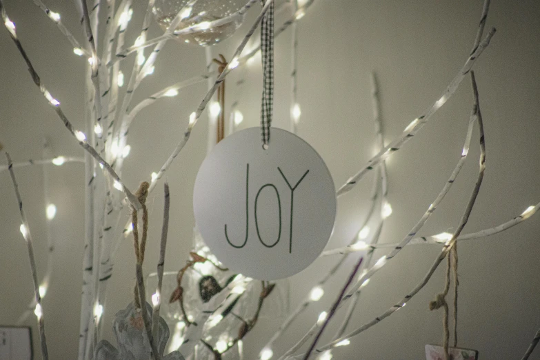 a number hangs from a tree with lighted string lights