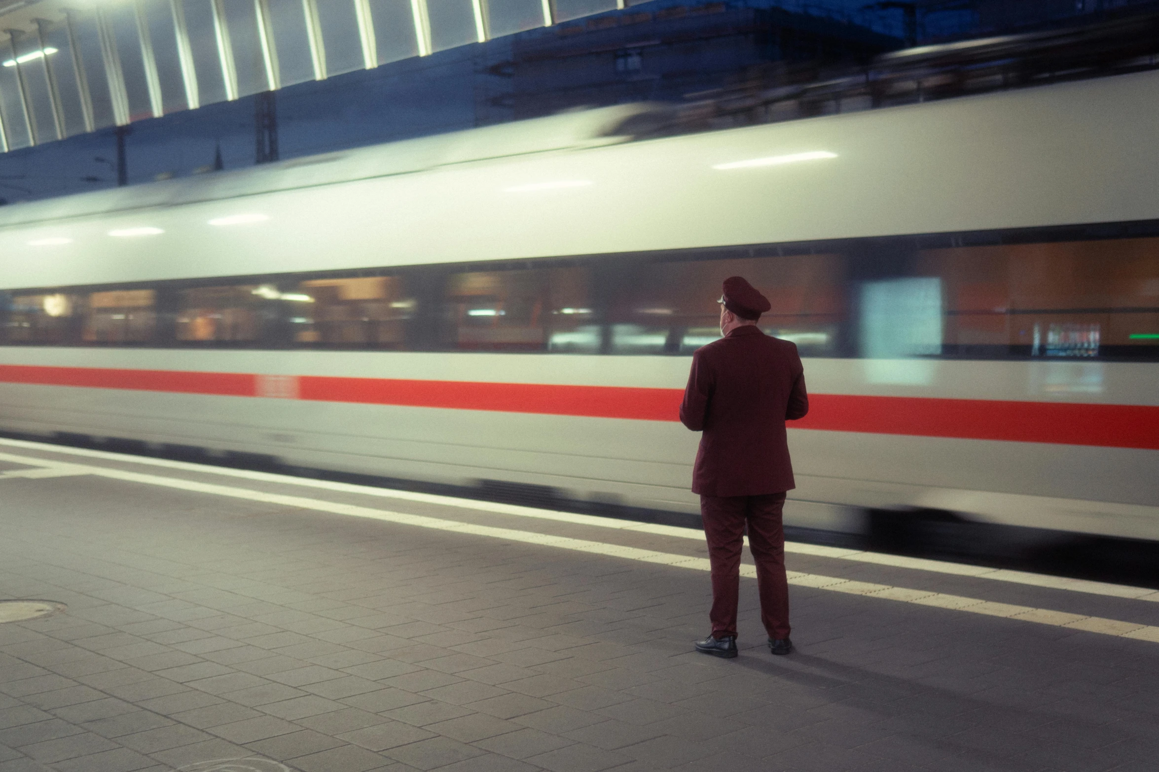 a man standing in front of a train at a train station, by Matthias Weischer, happening, unblur, thin red lines, facing away, still photograph