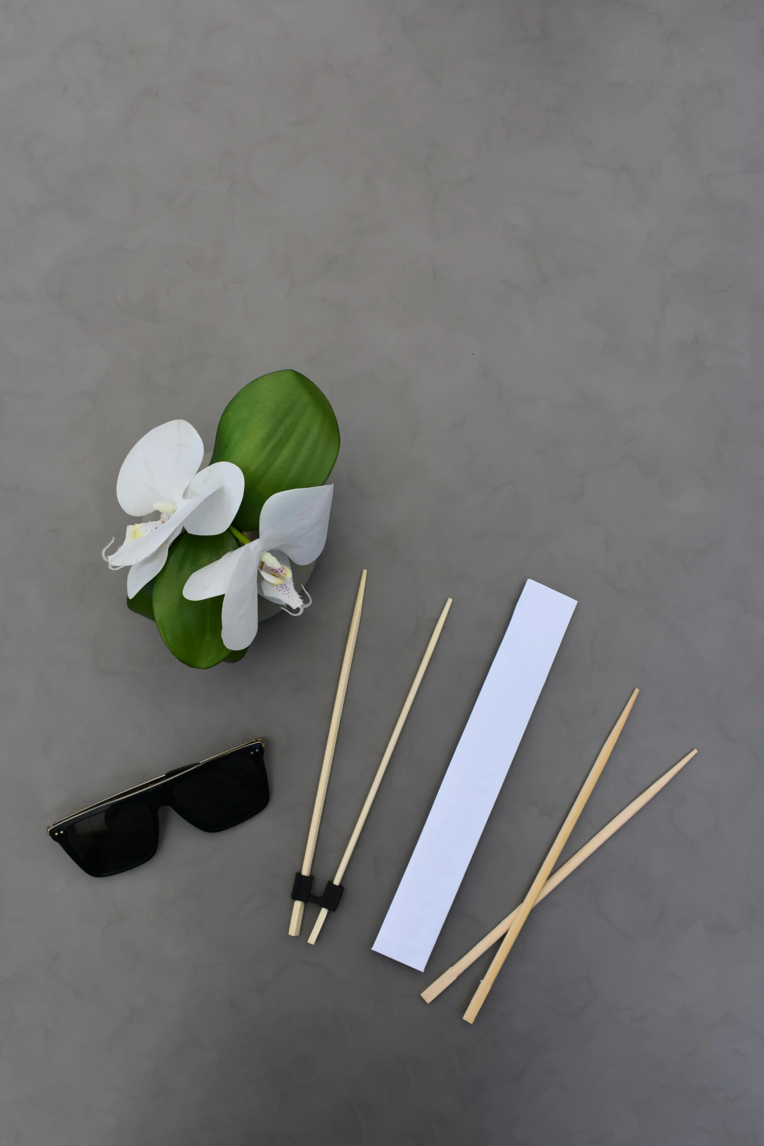 a bunch of sticks sitting on top of a table, a still life, inspired by Tōshi Yoshida, unsplash, minimalism, wearing facemask and sunglasses, white orchids, all black matte product, skewer