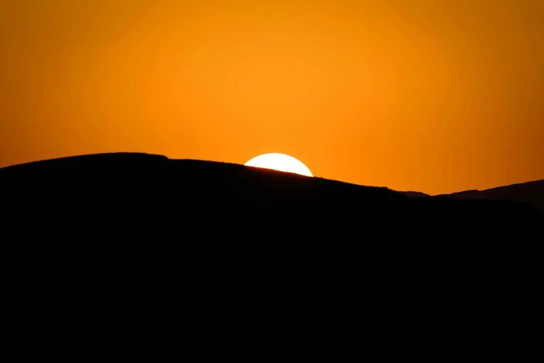 the sun is setting on top of a mountain, by Ian Fairweather, minimalism, shap, during an eclipse, silhouette :7, golden sun