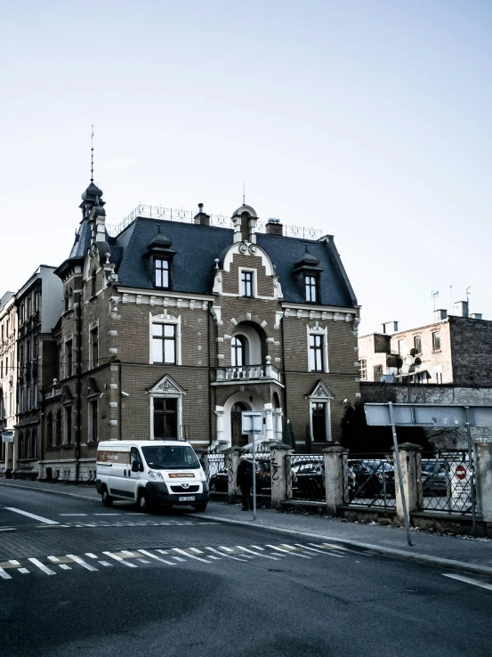 a group of cars driving down a street next to tall buildings, a photo, pexels contest winner, paris school, gothic mansion, in legnica, slide show, exterior view