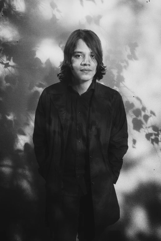 a man standing in front of a cloudy sky, a black and white photo, inspired by Jorge Jacinto, realism, frank dillane as puck, cynthwave, kuntilanak on tree, in a black suit