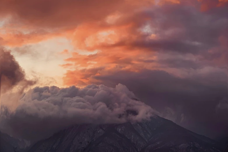 a group of mountains in the distance with a red and orange sky