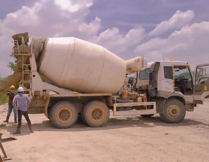 a man standing next to a cement mixer truck, inspired by Afewerk Tekle, unsplash, hurufiyya, low quality footage, concrete building, very kenyan, thumbnail