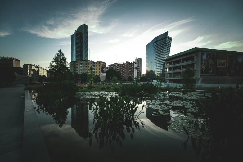 an old lake surrounded by buildings at sunset