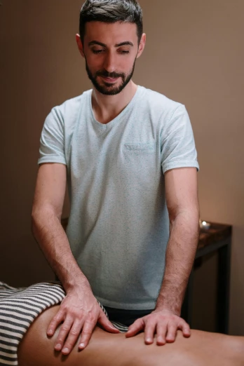 a man getting a massage in a room, wearing a light blue shirt, alessio albi, standing, brown