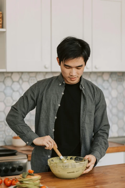 a man standing in a kitchen preparing food, inspired by Reuben Tam, wearing a linen shirt, spoon slim figure, wearing a flannel shirt, damien tran