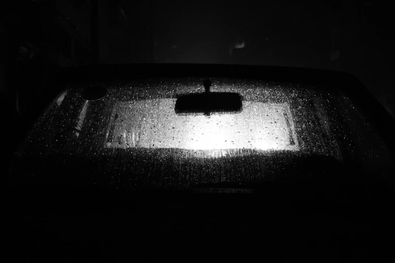 a black and white photo of a car in the rain, unsplash, window to night time, condensation drip, night time footage