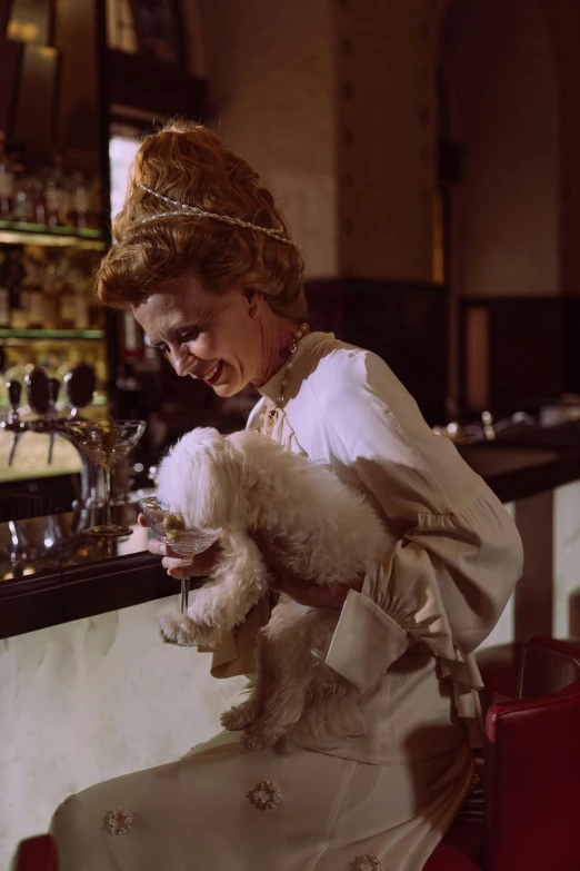 a woman holds her dog in the bar