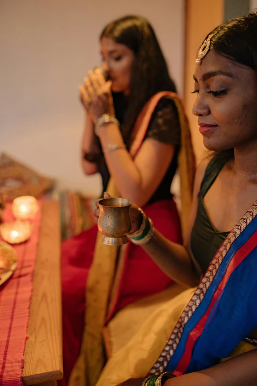 a couple of women sitting next to each other at a table, hurufiyya, hindu aesthetic, drinking, profile image, festive