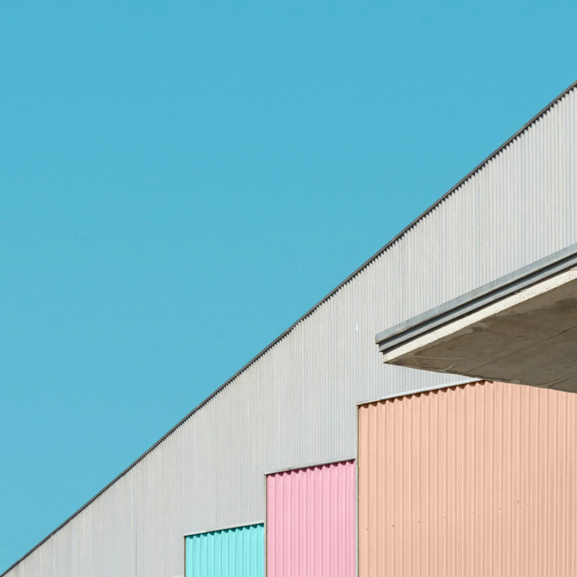 a multicolored building with a blue sky in the background, a minimalist painting, by Tobias Stimmer, pexels contest winner, postminimalism, warehouses, shipping containers, candy pastel, grey warehouse background