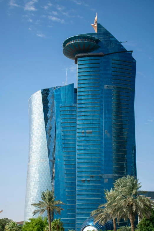 an elegant building surrounded by palm trees in front of a blue sky