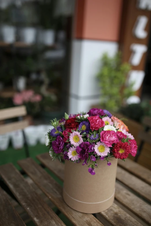 a flower pot sitting on top of a wooden table, wrapped in flowers, tasteful colors, full product shot, medium