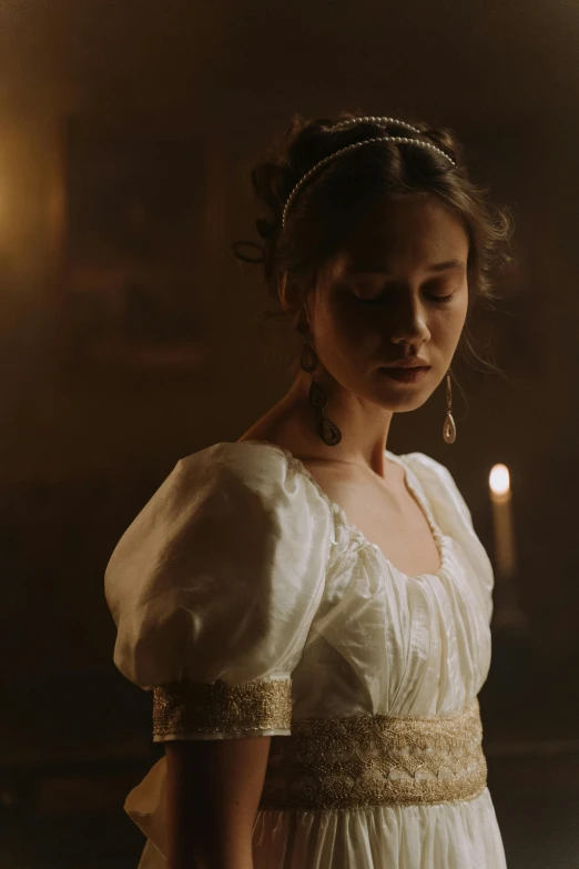 a young lady in dress looking down in dark room