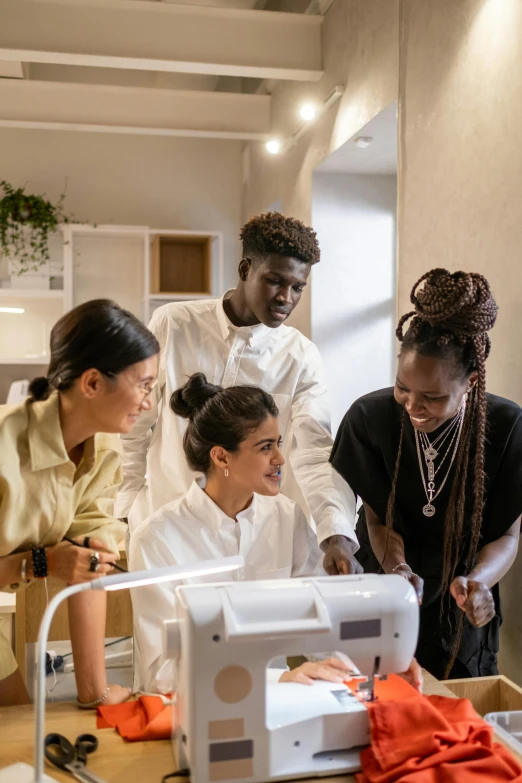 a group of people standing around a sewing machine, trending on pexels, renaissance, afro tech, with a lab coat, ignant, architect