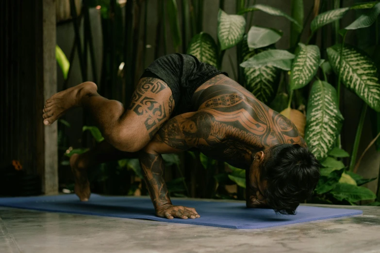 a man doing a handstand pose on a yoga mat, a tattoo, pexels contest winner, hurufiyya, covered in plants, profile image, malaysian, insectile forearms folded