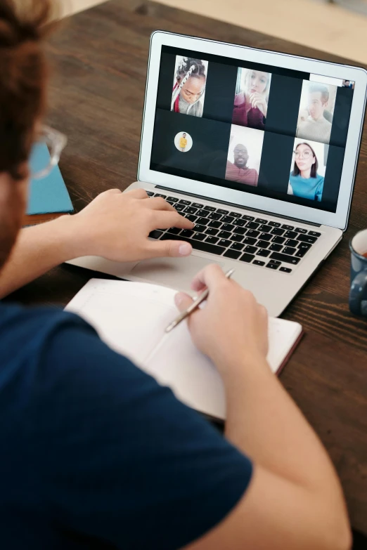 a person sitting at a table working on a laptop, a computer rendering, pexels, webcam, a group of people, photograph credit: ap, promo image