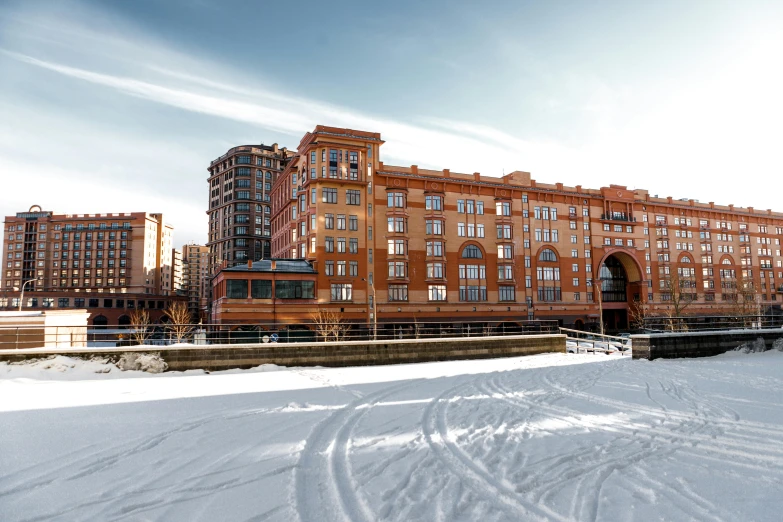 a large building sitting on top of a snow covered field, inspired by Edward Willis Redfield, pexels contest winner, city docks, louis sullivan, colorado, canals