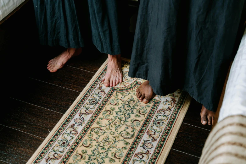 a person standing on top of a rug next to another person