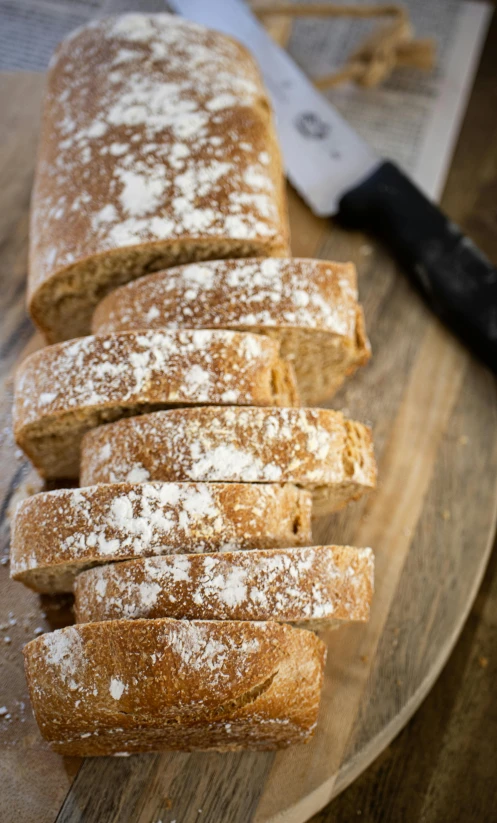 fresh made sliced bread on wooden table with knife