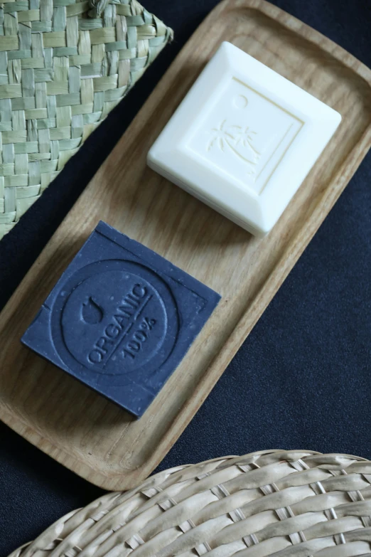a soap bar sitting on top of a wooden tray, a picture, inspired by Okada Hanko, bauhaus, indigo, embossed, kuang hong, chalk