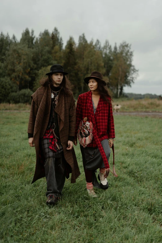 a man and a woman walking in a field, a portrait, unsplash, full body black and red longcoat, flannel, ruan jia and brom, baggy clothing and hat