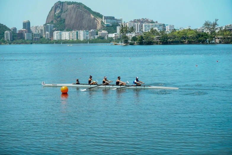 a group of people rowing across a body of water, oscar niemeyer, on a sunny day, scenery, set photo