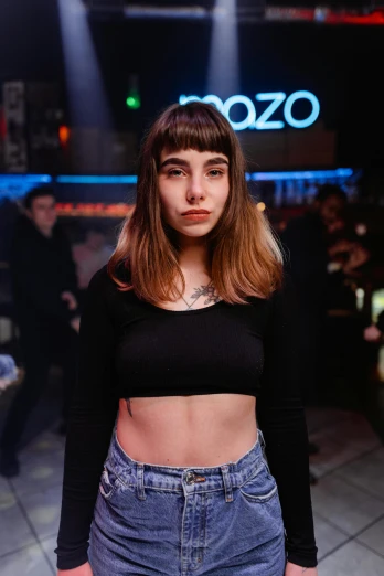 a woman standing in front of a crowd of people, an album cover, inspired by Elsa Bleda, trending on pexels, antipodeans, 🤤 girl portrait, wearing crop top, at a bar, bangs