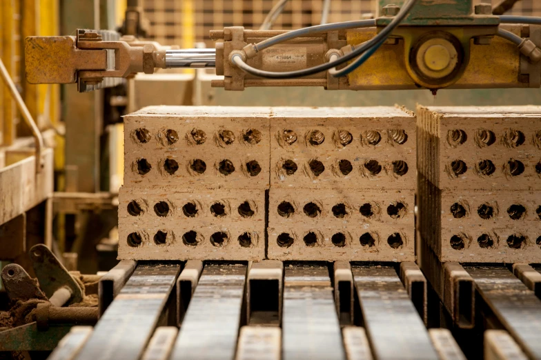 a bunch of bricks sitting on top of a machine, a portrait, unsplash, wooden casing, sustainable materials, tan