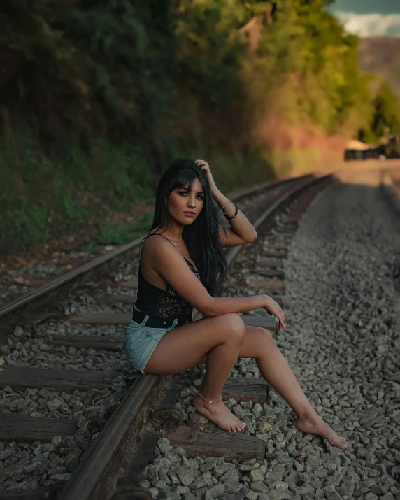 a woman sitting on the tracks by herself