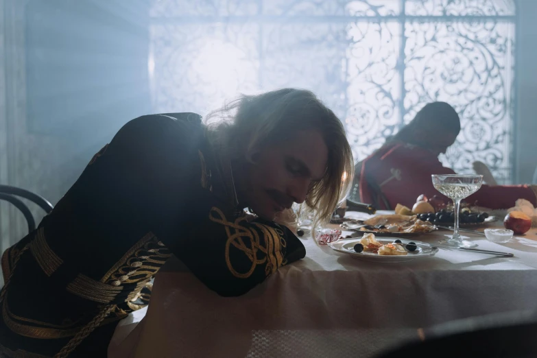 a woman sitting at a table with food and glasses