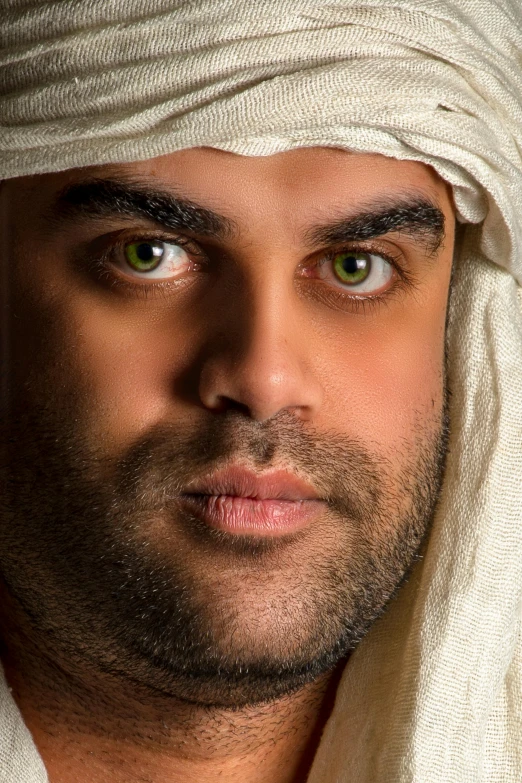 a close - up of a mans face with a white head wrap