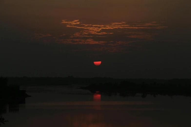 the sun setting in the sky over a body of water