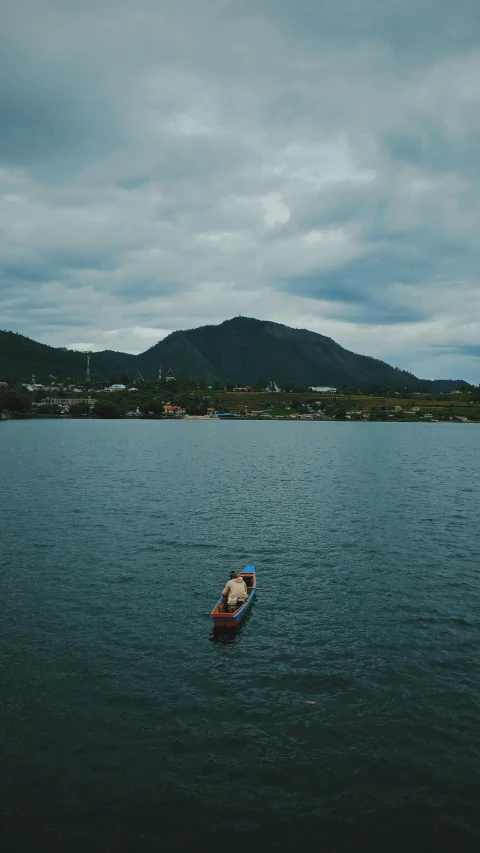 a man floating on top of a body of water, boats in the water, low quality photo, norway, 8k 28mm cinematic photo