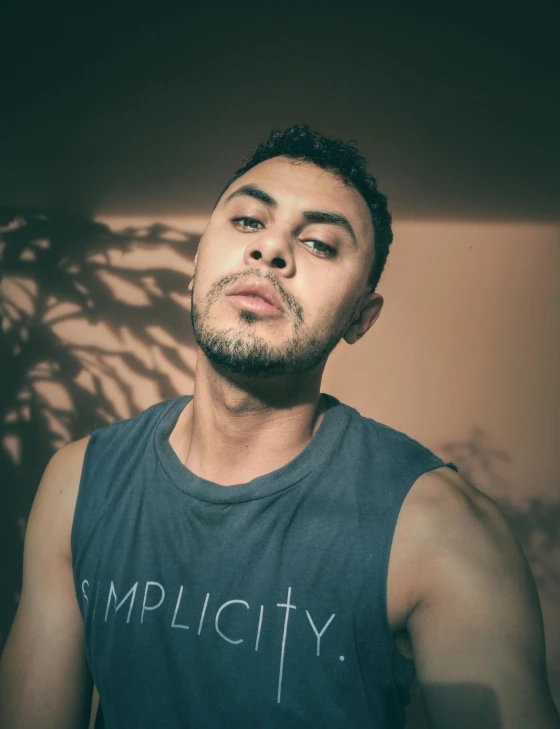 a man standing in front of a wall posing for a picture