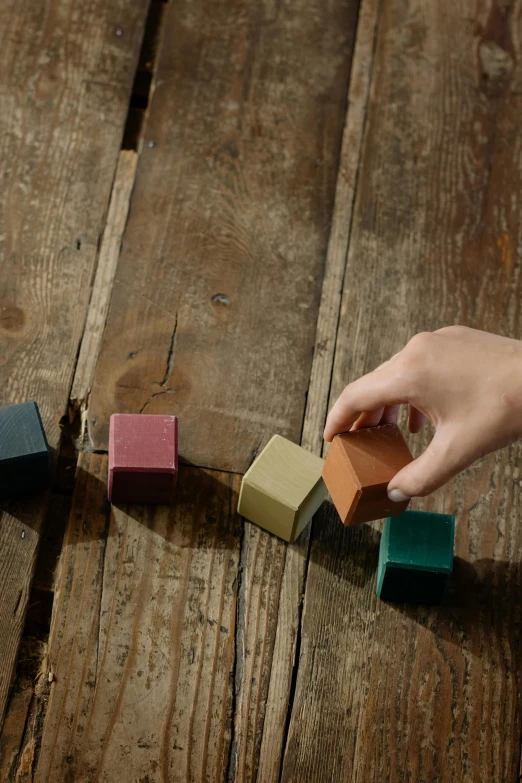 a person building blocks with a string on a wooden table