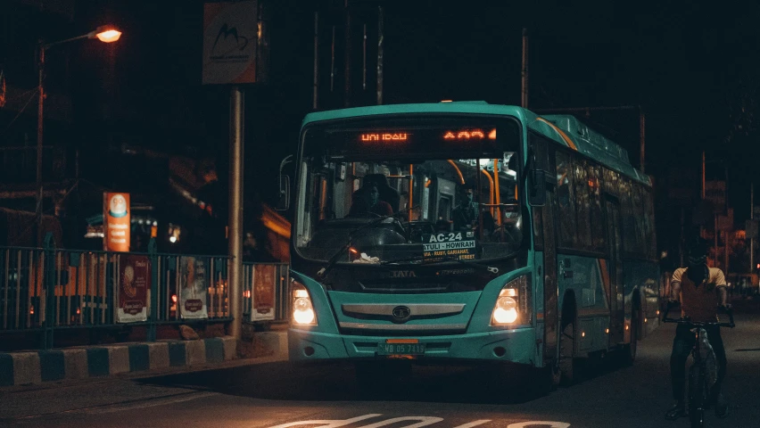 a large blue bus driving down a city street