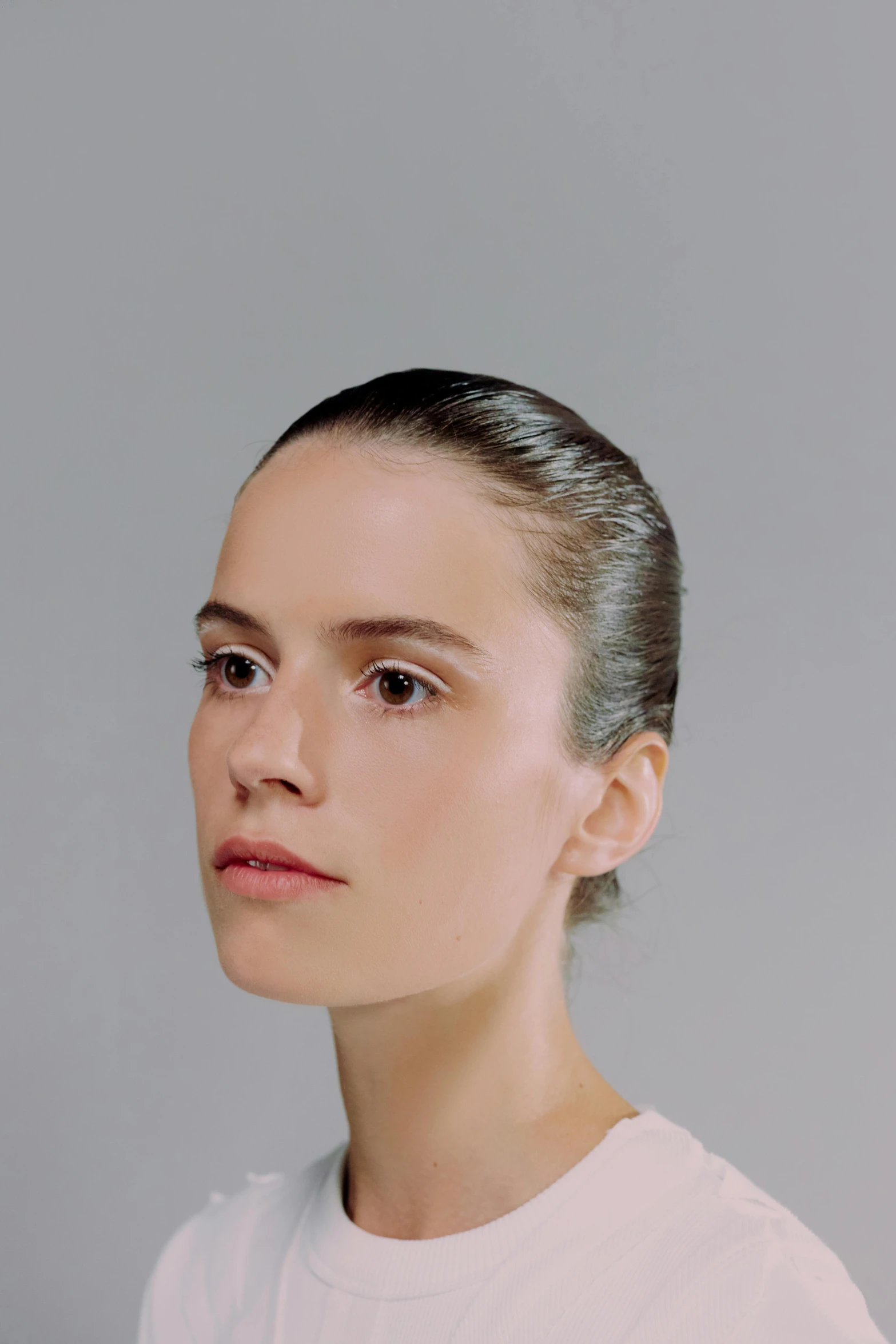 a woman in a white shirt looking off to the side, an album cover, inspired by Anna Füssli, dribble, hyperrealism, slicked back hair, head and shoulders view, highly reflective surface, portrait of a ballerina