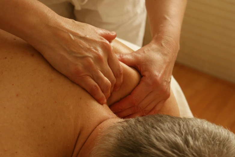 a man getting a back massage in a room, a photo, unsplash, portrait of hide the pain harold, manuka, multiple layers, elbow