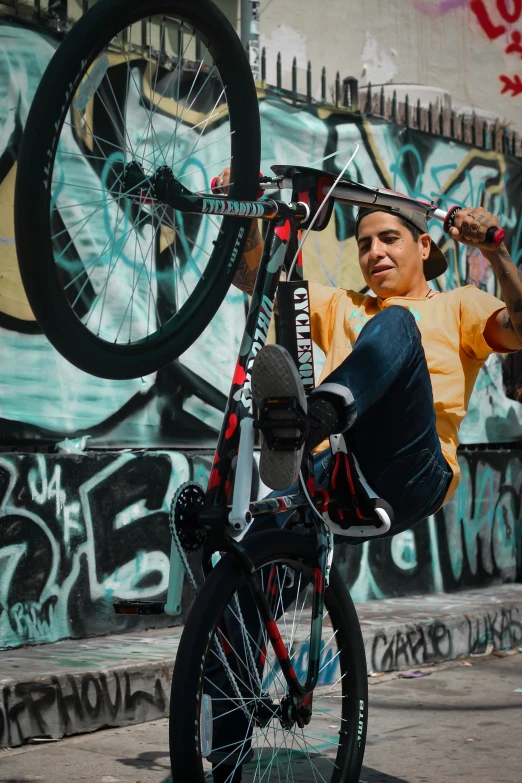a man is doing a trick on a bicycle, pexels contest winner, graffiti, portrait of danny gonzalez, sitting down, promotional image, teenager