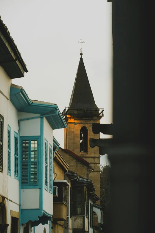 a couple of buildings that are next to each other, a picture, by Andrée Ruellan, pexels contest winner, renaissance, lead - covered spire, cyan shutters on windows, georgic, neighborhood outside window