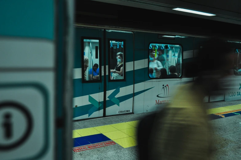 a blurry photo of a subway train at a station, a picture, by Alejandro Obregón, pexels contest winner, graffiti, white and teal metallic accents, chilean, people on the ground, game ready