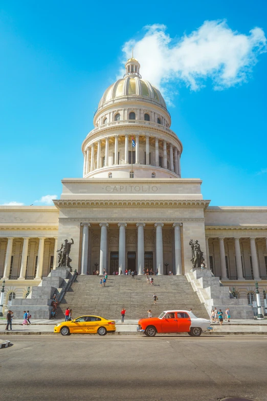 a po of a government building with cars parked in front