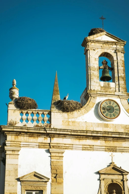 a church with a clock on the front of it, pexels contest winner, baroque, nazare (portugal), thatched roofs, seagull wearing luigis hat, square