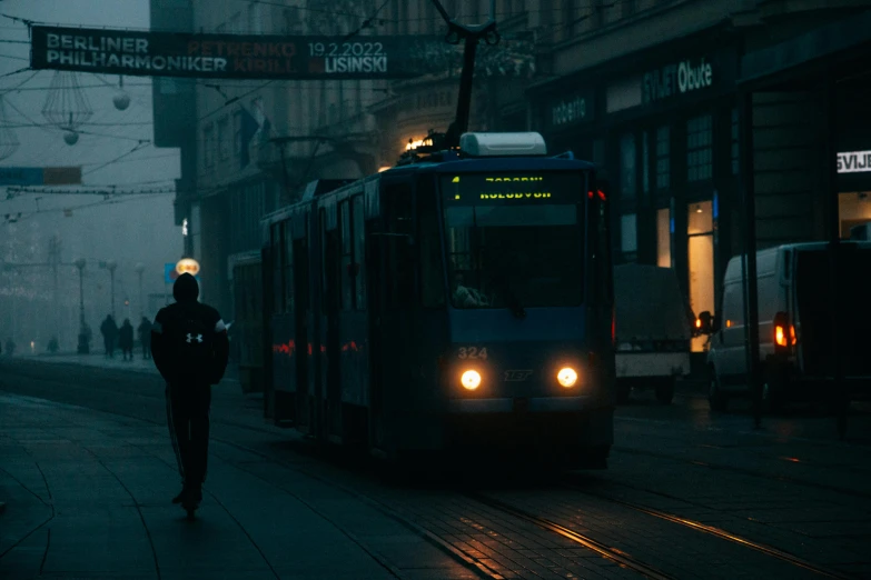 the train is traveling in the rain on the street