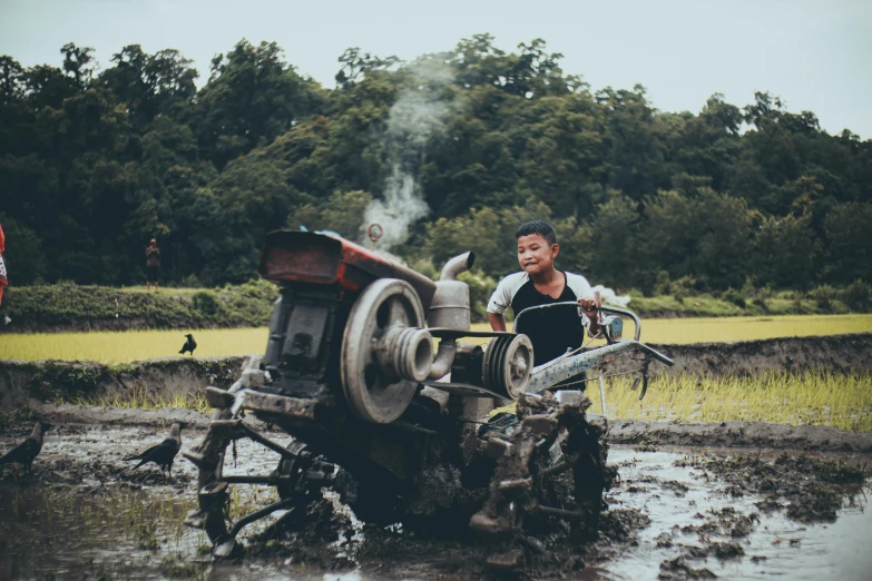 a man is plowing a field with a tractor, pexels contest winner, auto-destructive art, assamese aesthetic, avatar image, little kid, 90s photo